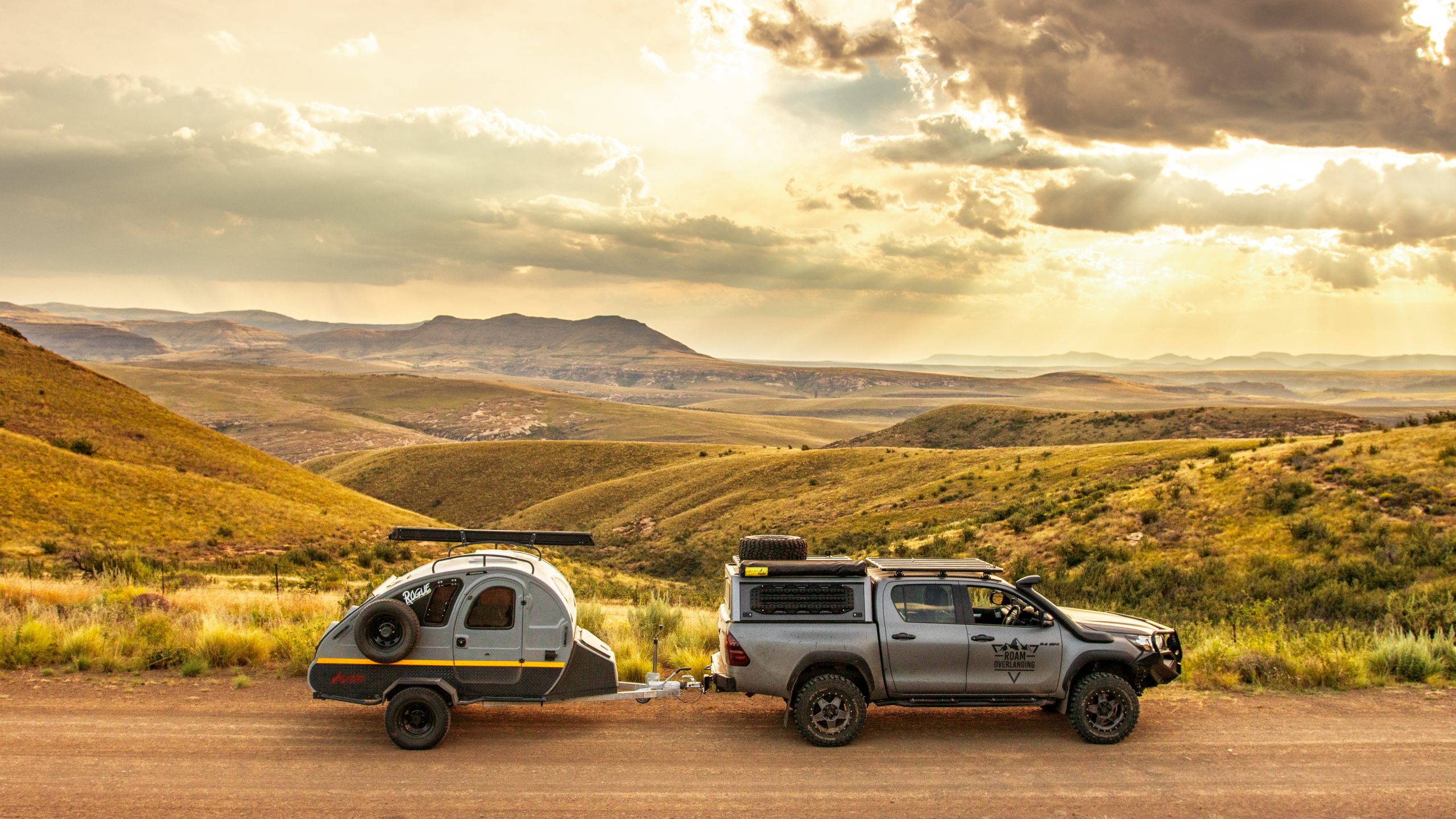 Vagabond caravan on a mountain pass at sunset